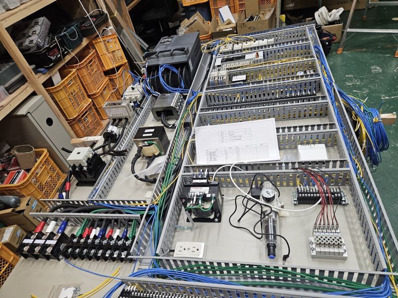 作業台の上で組み立て中の大型制御盤