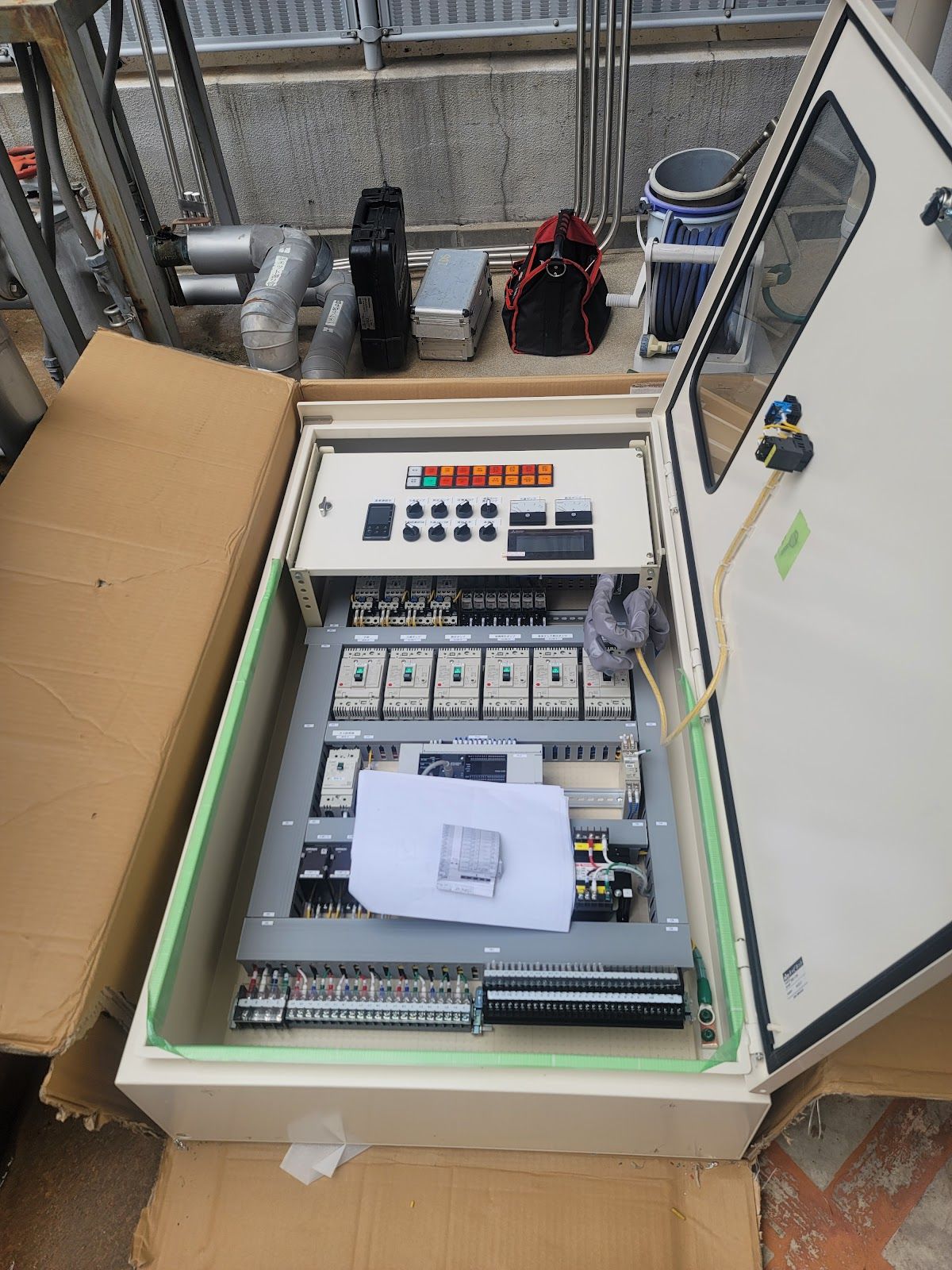操作部と盤内の機器が見える制御盤